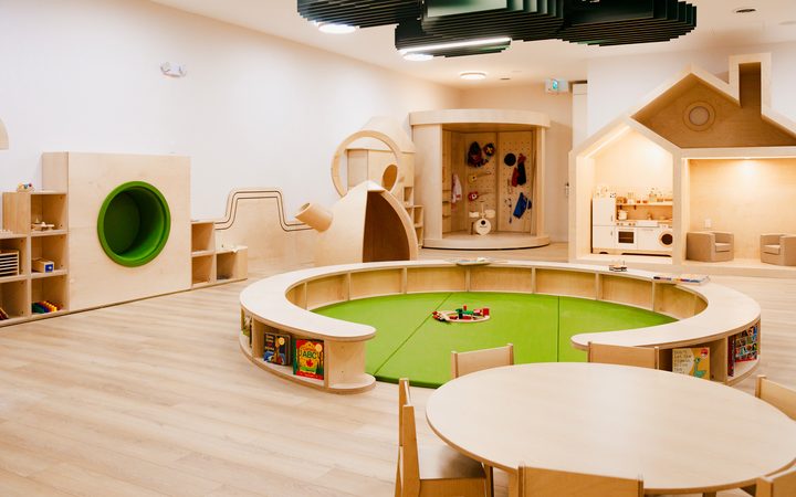 The Boogles Playhouse party room at Square One — birch play structures around a central green play pit