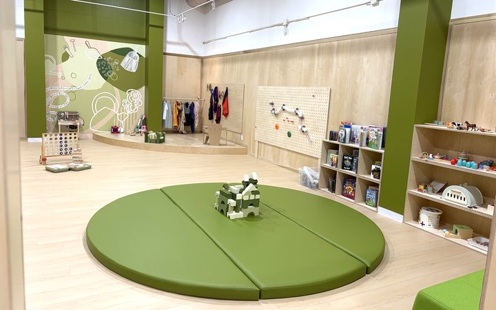 The Boogles Playhouse party room at Upper Canada Mall — a birch play space with a central green play mat and the Boogles mural wall
